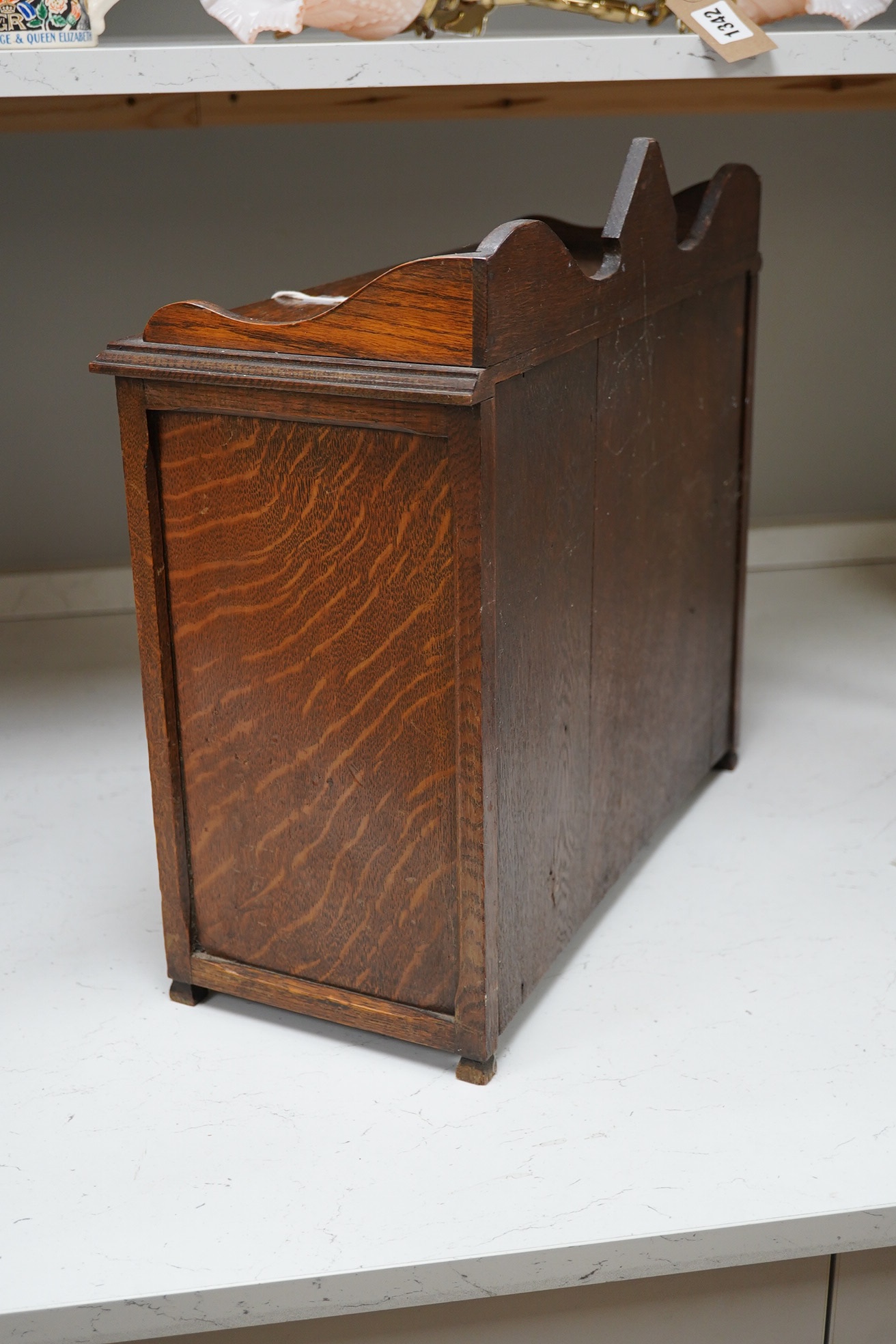 A carved oak smokers cabinet with Cartonware tobacco jar, cigar pricker and amber mouthpiece, 42cm wide. Condition - fair to good